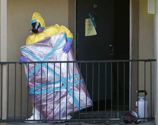 A worker in a hazardous material suit removes the contents of the apartment unit where a man diagnosed with the Ebola virus was staying in Dallas, Texas, October 6, 2014. Thomas Eric Duncan, the first person to develop Ebola in the United States, was struggling to survive at a Dallas hospital heightening concerns of the worst Ebola epidemic on record and has killed more than 3,400 people. REUTERS/Jim Young (UNITED STATES - Tags: HEALTH SOCIETY DISASTER) - RTR494ZY