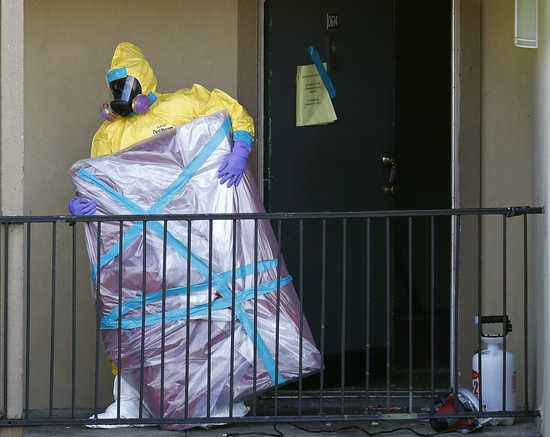 A worker in a hazardous material suit removes the contents of the apartment unit where a man diagnosed with the Ebola virus was staying in Dallas, Texas, October 6, 2014. Thomas Eric Duncan, the first person to develop Ebola in the United States, was stru