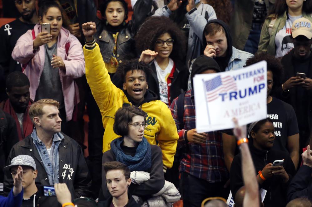 A protester raises his fist to supporters of Republican presidential candidate Donald Trump before a rally on the campus of the University of Illinois-Chicago.